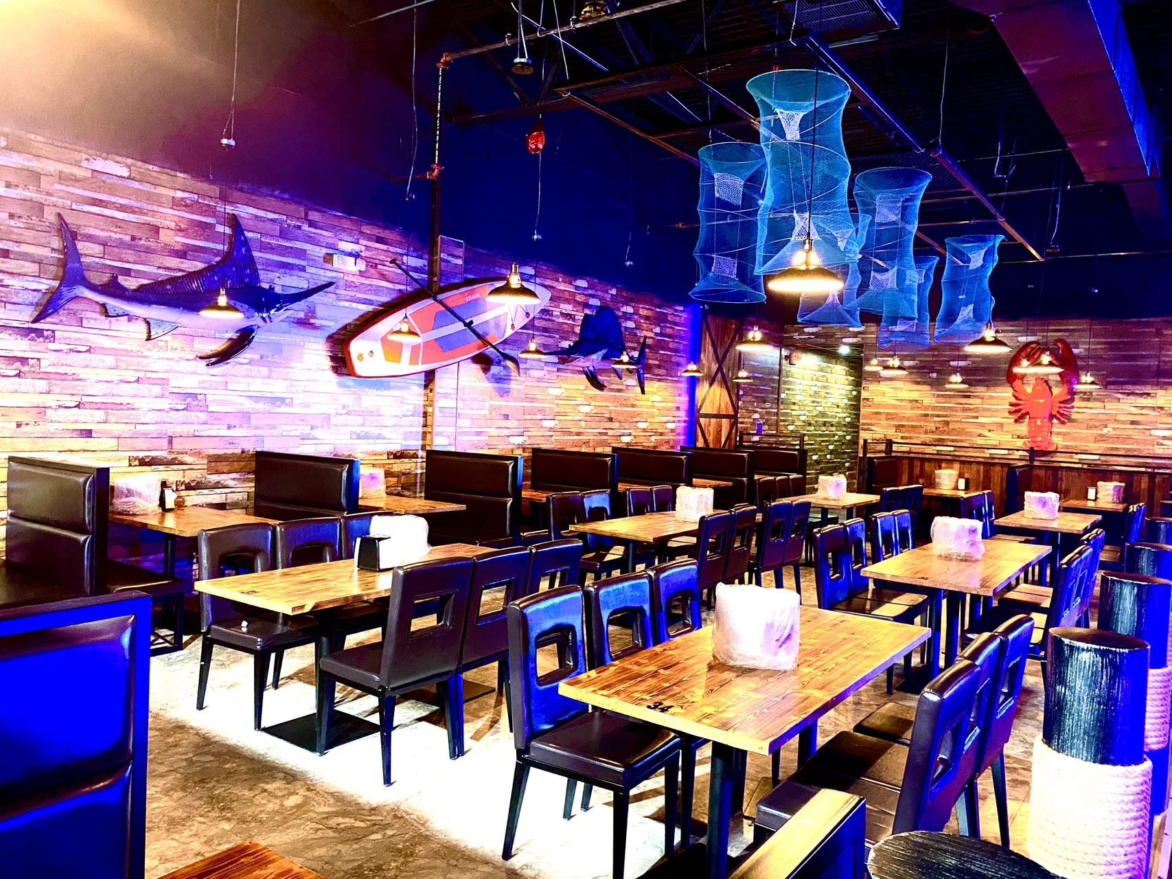Boil Bay dining room with nautical decor, fish wall art, and blue lighting