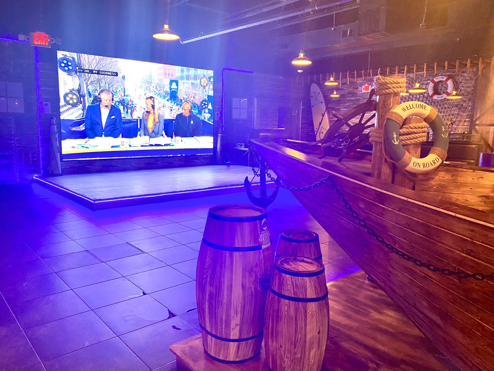 Large LED screen and stage area with pirate ship decor at Boil Bay